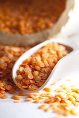 Red lentils on white wood background