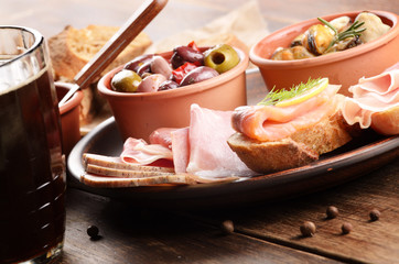 Tapas of salmon, mussels, jamon and olives with beer