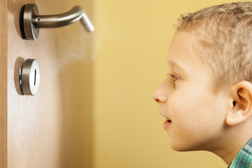boy looking through a keyhole
