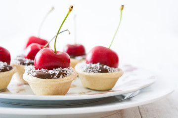 Delicious chocolate tartlets with chocolate, cherries and coconut


