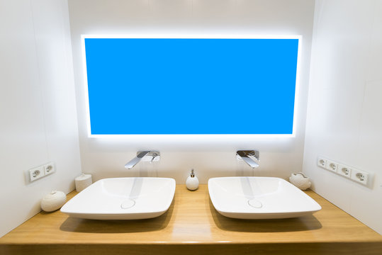 Two moderm sink in the bathroom, and big mirror with blue mask