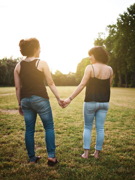 two female girlsfriends in a park holding hands