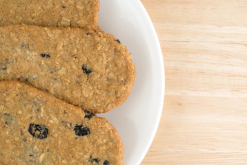 Blueberry wafer cookies on a white plate top close view on a table.