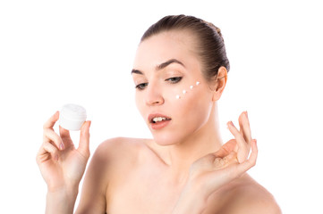 Young girl applying a natural face cream portrait isolated on white background. Skin care concept.