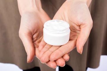 Beautiful clean woman's hands with a natural cream in a jar. Skin care concept.