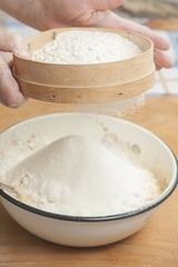 Fototapeta na wymiar Women's hands preparing flour before baking pie