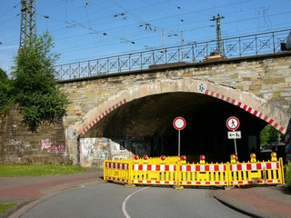 Instandhaltung einer alten Eisenbahnbrücke mit Vollsperrung vor blauem Himmel im Sonnenschein am...