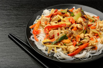 Rice noodles with vegetables, mushrooms, chicken and soy sauce.
