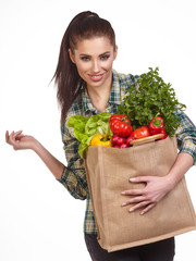 Isolated woman holding a shopping bag full of vegetables