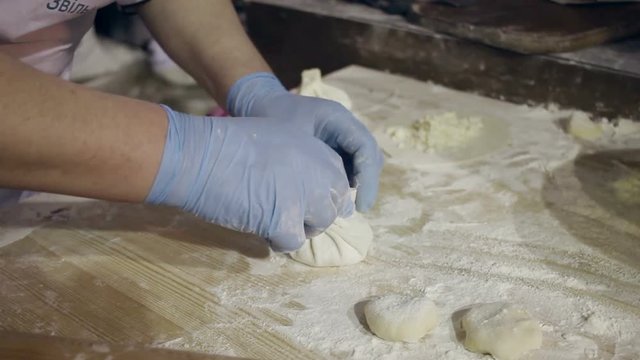 Cooking food. Cooking georgian dumplings. Process of cooking khinkali. Chef hands form dough. Traditional georgian dumplings stuffed with minced meat. Mens hands hold khinkali from dough