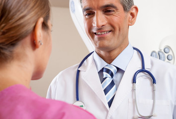 Male doctor smiling to female patient in the hospital