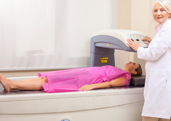 Female patient undergoing x-ray scan with professional assistanc