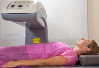 Happy woman undergoing open MRI scan