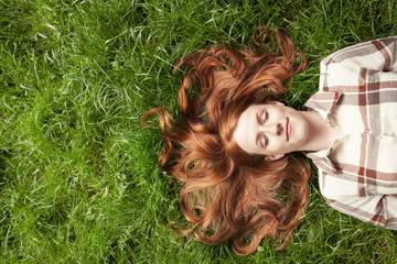 Teenage girl laying in grass