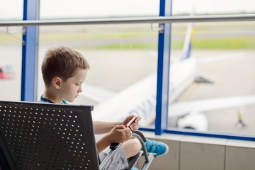 Bored 7 years old boy child waiting for his plane