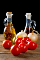 tomatoes and bottles of olive oil on rustic table