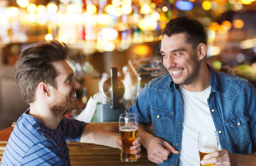 happy male friends drinking beer at bar or pub
