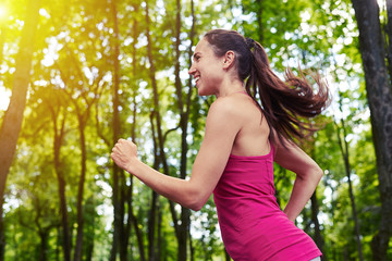  Fit girl jogging in the park on sunny day