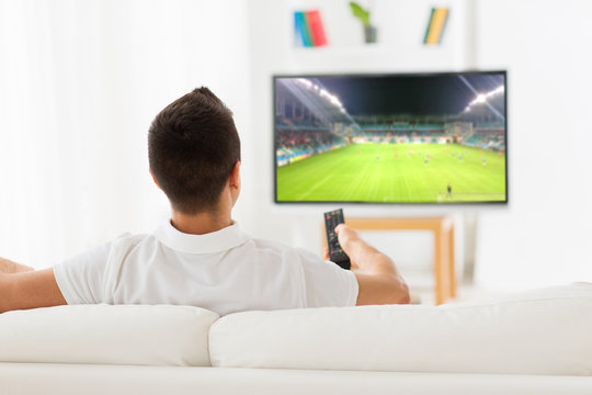 Man Watching Football Or Soccer Game On Tv At Home