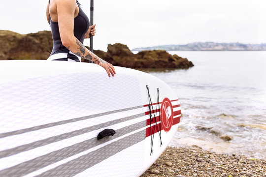Woman with stand up paddle board at the coast