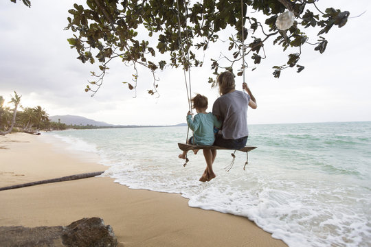 Thailand, family on beach, sitting on swing
