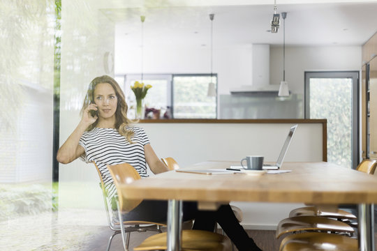 Woman on cell phone sitting at table