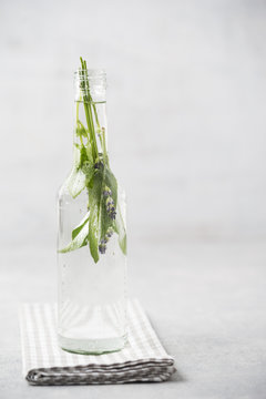 Glass bottle of water flavoured with sage, lavender and lemon balm
