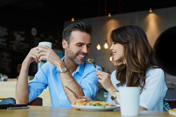 Happy couple at restaurant eating lunch, having fun