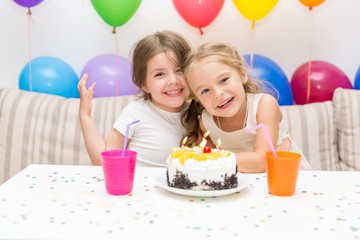 Obraz na płótnie Canvas Birthday girl and her friend enjoying a birthday party