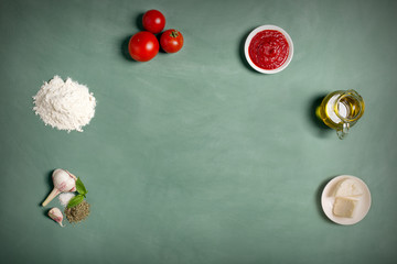 Ingredients of pizza on the green chalkboard (top view)