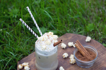 ice cocoa with cinnamon and whipped cream adorned with caramel popcorn