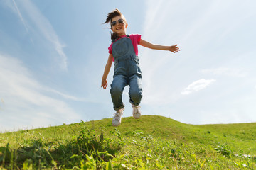 happy little girl jumping high outdoors