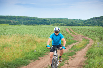 Fototapeta na wymiar Cyclist on a white bicycle in a blue uniform rides