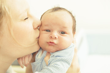 Mother kissing her newborn child
