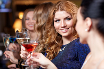 Fototapeta na wymiar happy women with drinks at night club