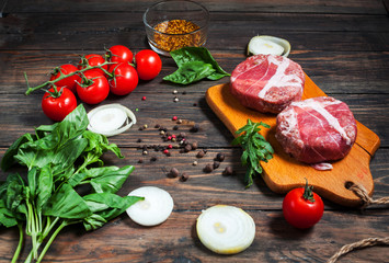 Ingredients for making homemade burger on wooden cutting board.