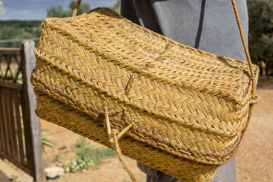 Detail of farm worker holding a traditional wicker basket used to keep the food, known in Andalusia as "capacha"