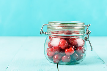 Jar Of Red Fresh Cherries On Turquoise Background