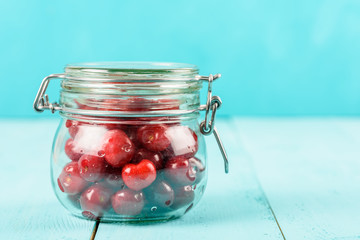 Jar Of Red Fresh Cherries On Turquoise Background