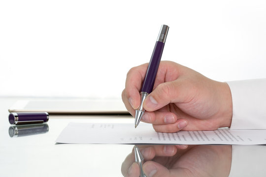 Hand with pen over application form, Businessman signing a contract with ballpoint concept.