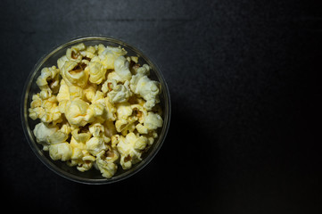Caramel popcorn on dark background with hard light, modern luxury concept