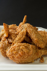 fired chicken on a white plate and black background
