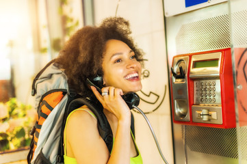 Smiling woman using public phone