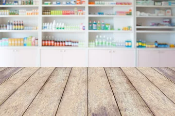 Photo sur Plexiglas Pharmacie comptoir en bois de pharmacie avec étagères floues de médicaments dans la pharmacie
