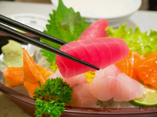 red tuna fish slice sashimi in chopsticks with tuna, salmon sash