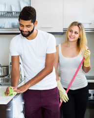 Obraz premium Couple cleaning in the kitchen