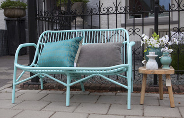 Vintage bamboo chair or sofa and pillows with pastel colors and still life on a garden table.