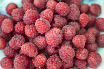 Ripe raspberries on a plate. Selective soft focus