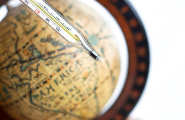 broken thermometer with vintage globe background
