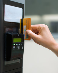 Woman using bank card in payment terminal.